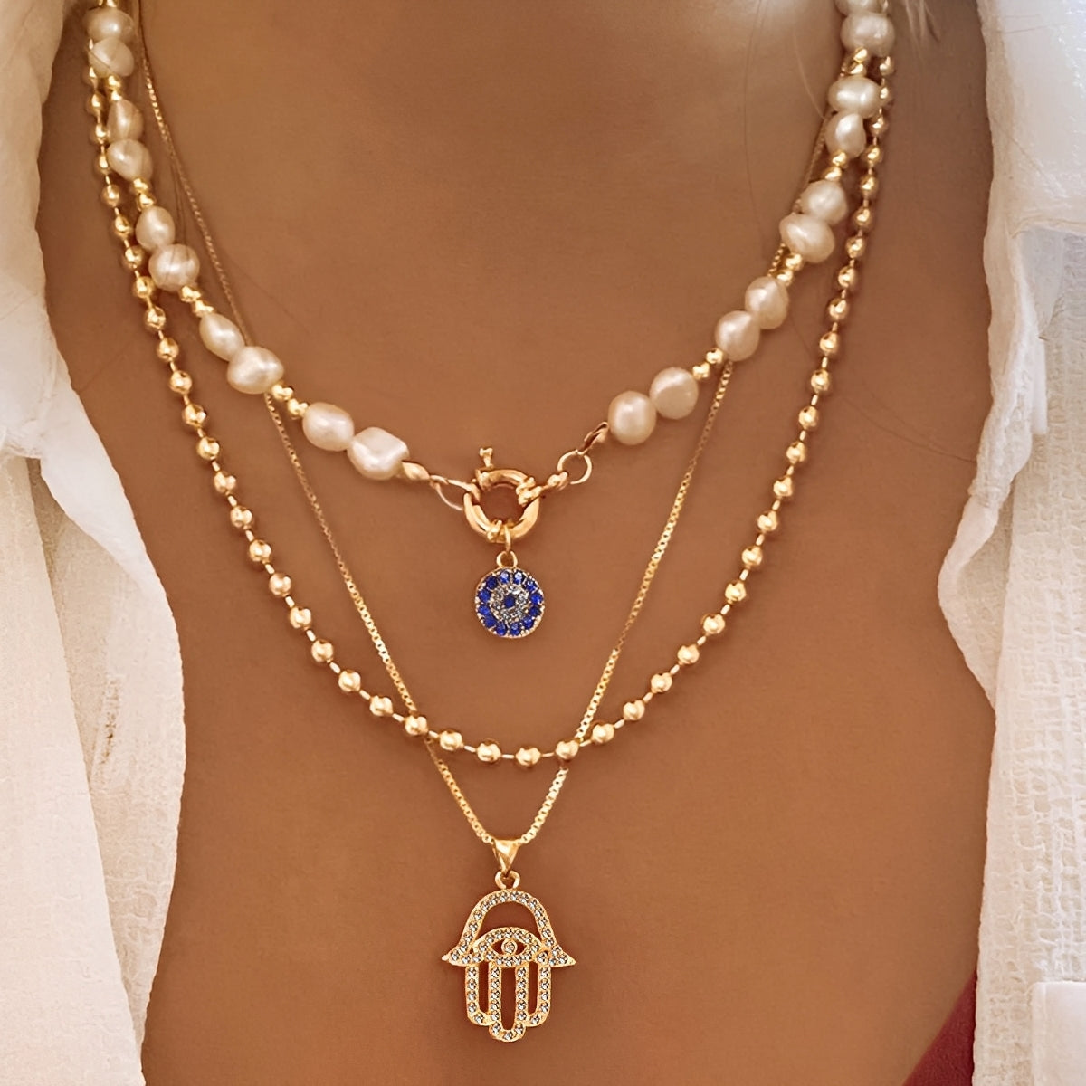 Nadia – Halskette mit mehreren Reihen Perlen und Hamsa-Hand
