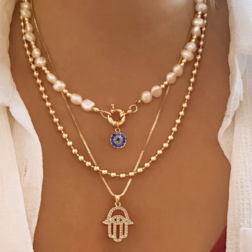 Nadia – Halskette mit mehreren Reihen Perlen und Hamsa-Hand